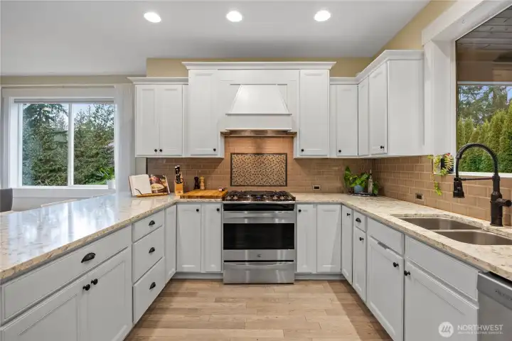 Wonderful kitchen with quartz countertops, propane cooktop, 2 ovens (don't miss the wall oven behind you in this photo), and countertop seating.