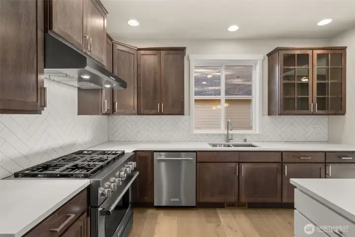 Kitchen features quartz counters, hardwood floors, ample cabinetry. Photo shown for layout, note the colors will vary.