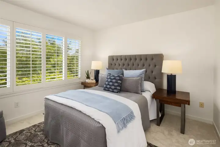 The primary bedroom has plantation shutters and overlooks the green space out back. The primary bedroom has plantation shutters and overlooks the green space out back.