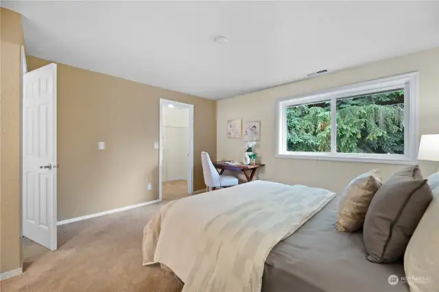 The second bedroom features fresh paint, cozy carpeting, and a large window overlooking the backyard. It includes a walk-in closet and an en-suite full bath, offering both comfort and convenience.