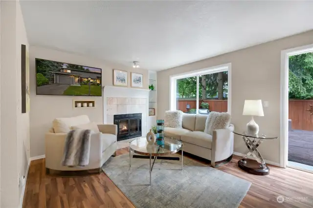 This cozy living room features a fireplace, elegant laminate floors, and a large sliding glass doors that open to your private deck. The tasteful decor and natural light create an inviting space perfect for relaxation and entertaining