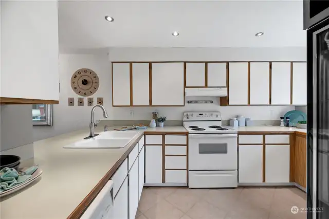 This bright and spacious kitchen features ample cabinetry and counter space, ideal for entertainment and storage needs. There's updated recessed lighting above, which brightens both the room and your spirits.
