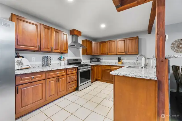 Open concept kitchen with rich cabinetry, tons of counter space and quartz counters