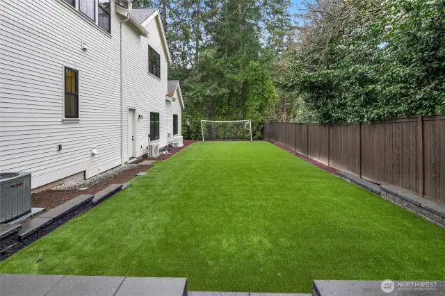 A Side Yard Customized with Turf Perfect for Soccer, Cornhole, or your Own Personal Favorite Summer Game.