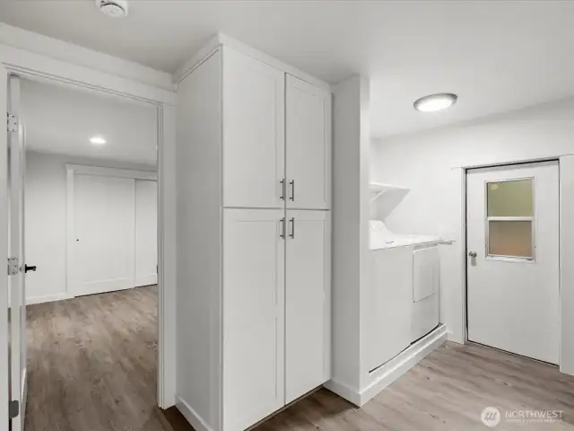 Door to the rear deck to the right, Laundry with storage center and door to Primary Suite at the left.