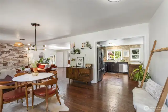 As you enter you are greeted by the dining area, living area off to the left and kitchen straight ahead.