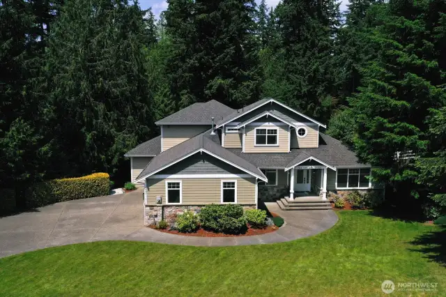 This stunning custom home offers timeless curb appeal with craftsman-inspired architecture, stone accents, and a welcoming covered entry. Tucked into a private, setting, the residence is surrounded by mature landscaping and features a spacious driveway with elegant curved design.