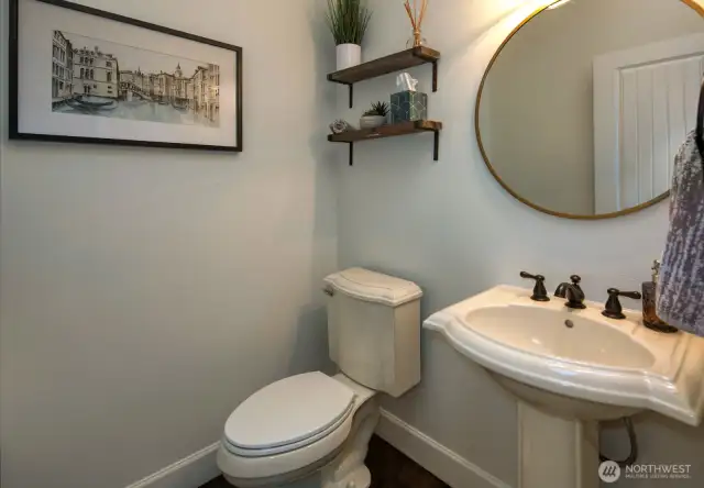 Stylish powder room features elegant pedestal sink, all new matte fixtures, floating wood shelves.
