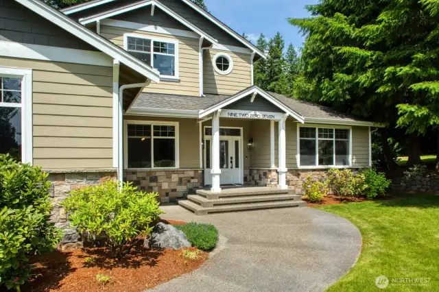 Front Entry features a wide stairway, charming covered porch, and detailed stonework.
