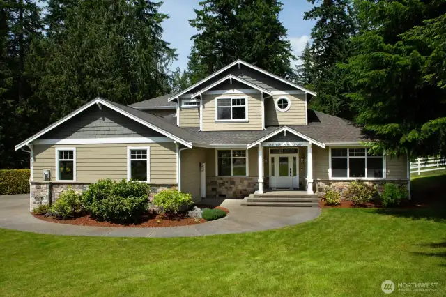 A wide stairway, charming covered porch, and detailed stonework that perfectly complements the natural surroundings.