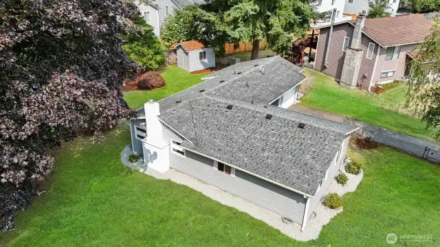 Mature trees bring shade to the private, fully fenced yard. Green grass has been digitally altered in photo.