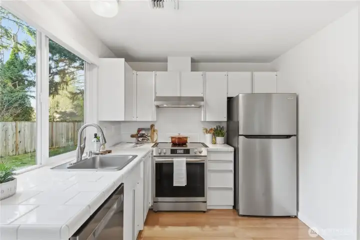 Tile counters and stainless steel appliances are ready for your meal preparation.