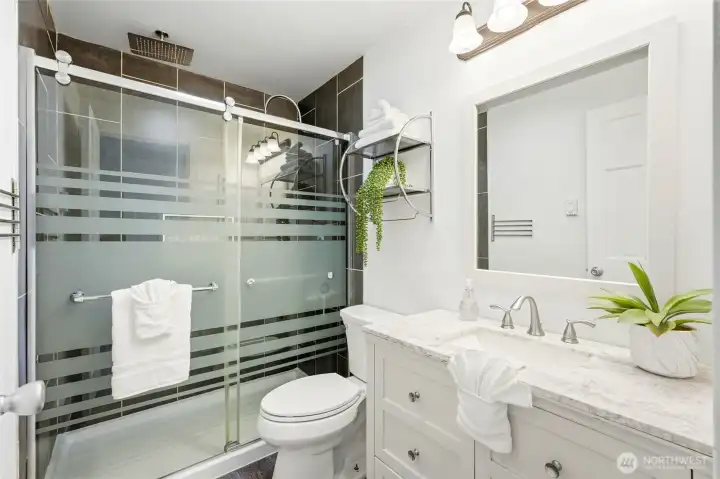 Spa-inspired ensuite bath that feels like a luxury escape. Walk-in shower with floor-to-ceiling tile creates a high-end, modern look.  Rain shower head and built-in Bluetooth speaker turn routines into relaxation.