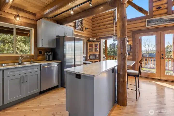 What chef wouldn't love crafting fine meals here with so much natural sunlight and beautiful cabinets and quarts counter tops.