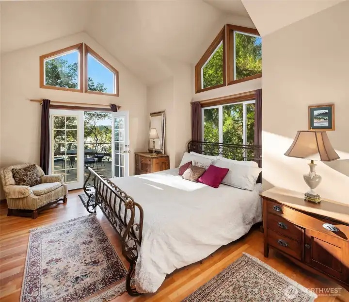 Primary bedroom on North side main level opens to deck through French doors