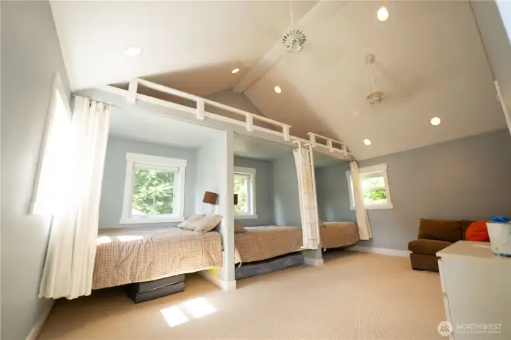 Ultimate bunk room upstairs with en suite bathroom, custom built-in beds, and loft.