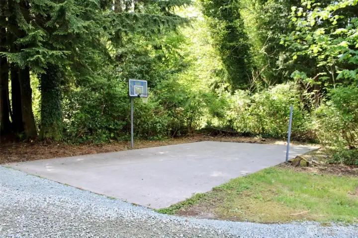 Sport court with basketball hoop and net posts.