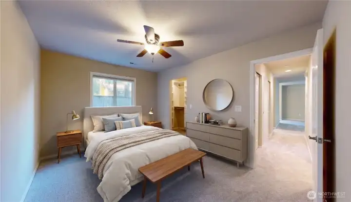 Primary bedroom suite featuring a large window, a ceiling fan, and seamless access to a spacious walk-in closet with custom built-ins. This photo is virtually staged.