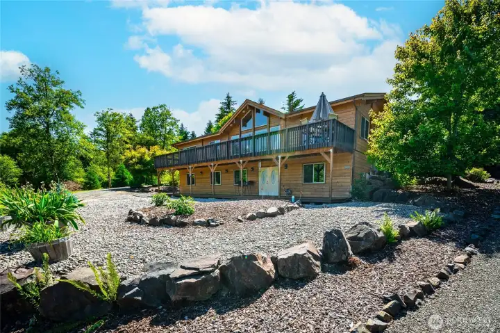 Full elevation from circular driveway approach on east, showing home nestled on private hillside Full elevation from circular driveway approach on east, showing home nestled on private hillside