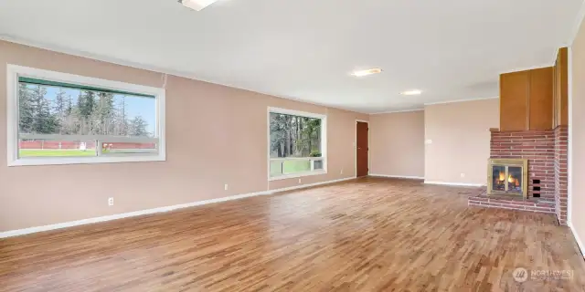 Living room features original hardwood floors & wood burning fireplace