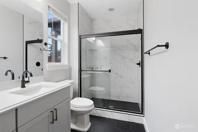 Master bath features full tiling, blending durability with a chic, contemporary look for a spa-like atmosphere.