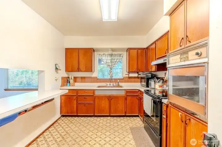 From the kitchen window, you can take in a peaceful view of the surrounding trees, a reminder of the privacy this property offers. The kitchen itself is spacious and ready for use as it is, while also providing the opportunity for updates if you’d like to put your own stamp on the space!