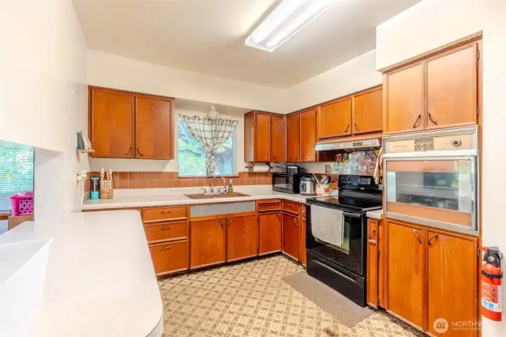 The wall oven on the right has long since stopped working, but the kitchen remains fully functional with a standard oven ready for everyday use. It’s a reminder that while the home has its original touches, there’s plenty of opportunity here for updates if / when you are ready!