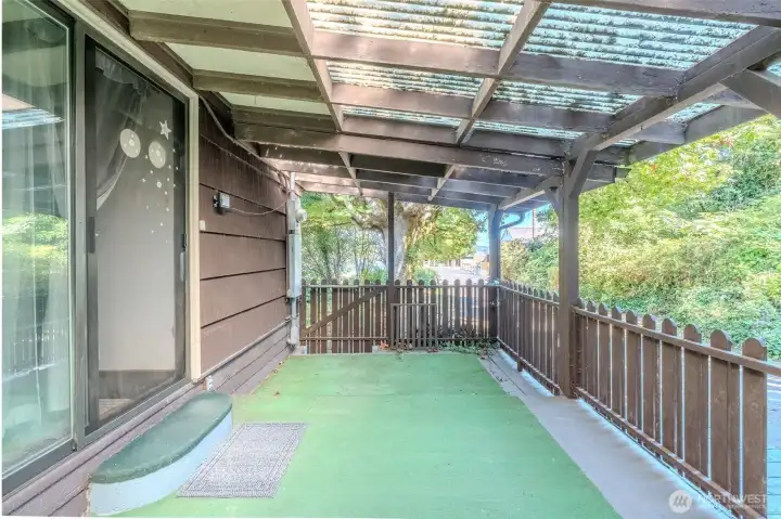 Just off the kitchen, the covered side patio provides a sheltered spot that can be enjoyed in any weather. It’s the kind of place where you can start the day with a quiet cup of coffee, surrounded by the trees that give the property its sense of privacy and calm.