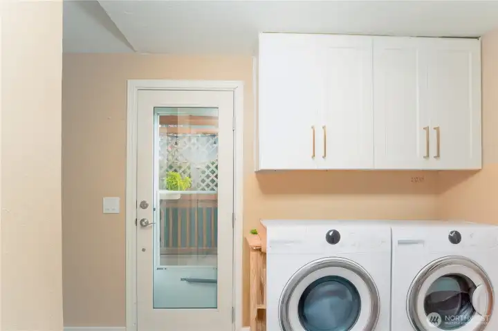 Laundry area with ample storage; washer and dryer virtually staged for visual reference.