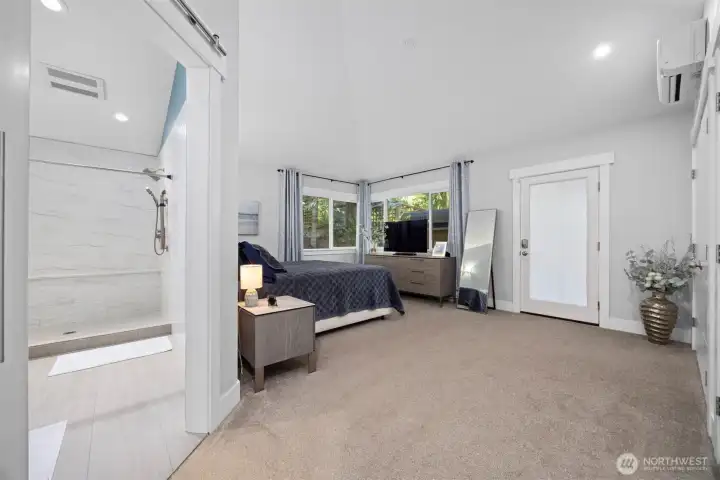 Primary bedroom on the main level with access to a private deck and cedar sauna.