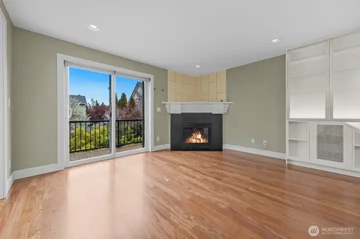 A warm and inviting living room features a cozy fireplace and flows seamlessly into the open kitchen, creating the perfect space for both everyday living and entertaining. The open-concept design enhances connection and natural light throughout the main level.