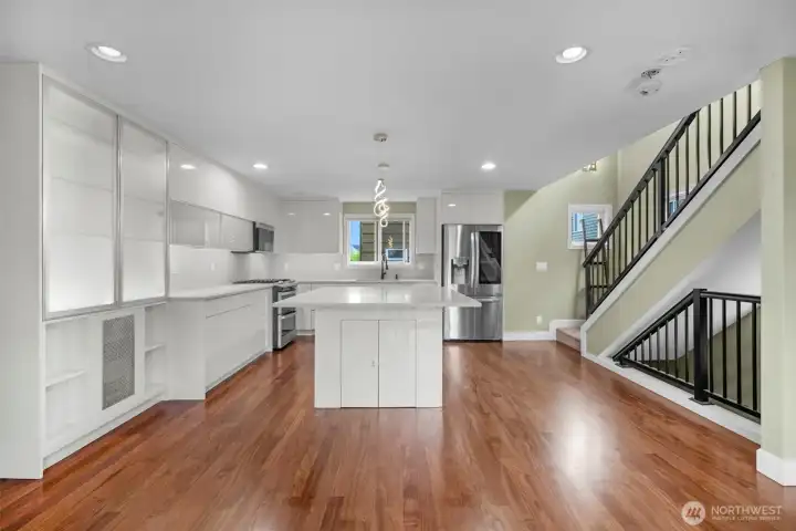 A bright, open view from the living room into the kitchen highlights the seamless flow of the main level, creating an airy and connected living space. The open-concept design enhances natural light and makes the home ideal for both everyday living and entertaining.