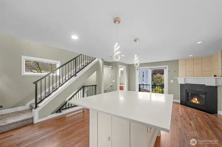 The kitchen opens seamlessly into the living space, anchored by a large island that serves as the perfect centerpiece for gathering, dining, and entertaining. This open-concept design enhances flow and functionality, creating a bright and connected main level ideal for modern living.