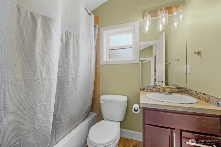 A conveniently located secondary bathroom offers a clean, functional design with modern finishes, providing ease of access for guests and everyday use. Thoughtfully positioned, it adds comfort and practicality to the home’s layout.