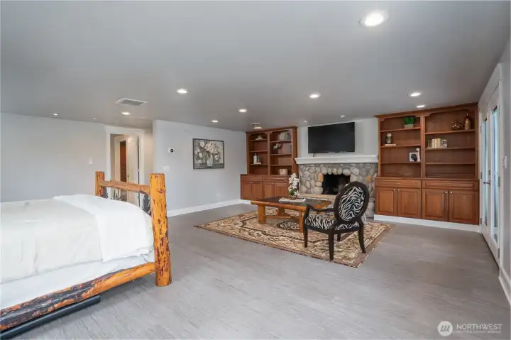 The owner's suite on the lower level is the perfect retreat to relax and unwind. The cozy woodburning fire place helps set the mood! The doorway on the left leads to the 5pc bathroom and walk-in closet. The beautiful built-ins are the perfect space to display your special treasures!