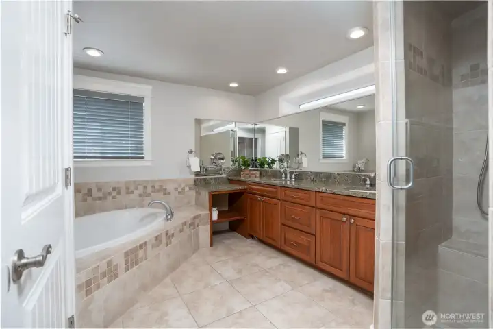 Ample 5 Piece "Spa Like" Primary bathroom, with tile flooring, double vanity with granite tops, separate water closet, a large walk in tile shower with multiple shower heads & large soaking tub.
