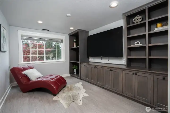 Gaming room with a wall of built-in cabinets - offering plenty of room for storage + TV conveys