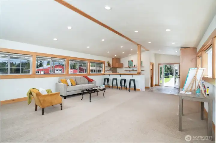 Looking back at the entry you will notice how much openness this space offers with wood wrapped windows,  custom cabinetry and a bar seating area adjacent to the kitchenette - a great place to gather! Just think of all the possibilities this room can offer you!