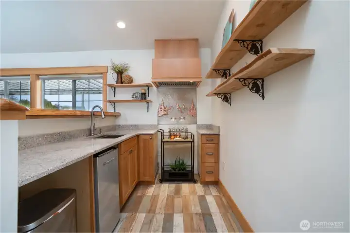 Kitchenette with sink & fridge, lots of cabinets to store your items and quartz counter tops plus live edge bar top and shelving adds a touch of style!