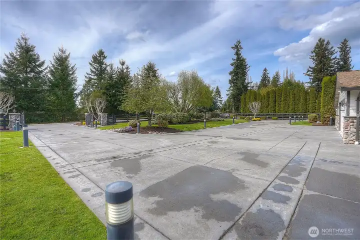 The grand entry - the view looking from the home! Beautiful concrete driveway, with dual entry with stone columns, wrought iron gates, lighting and extraordinary landscaping!