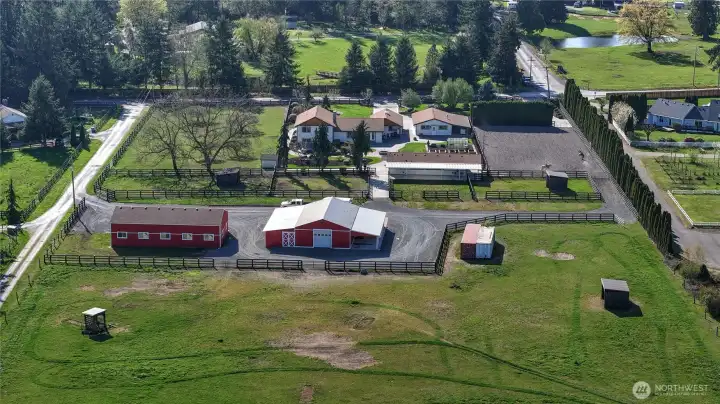 Looking from the backside of the property facing west - you will see the iconic Webster Rd as the western border of this fabulous estate. Notice the loafing shed in the pastures, which is ideal for year-round turnout. Conex units are fantastic storage and do convey with the property.