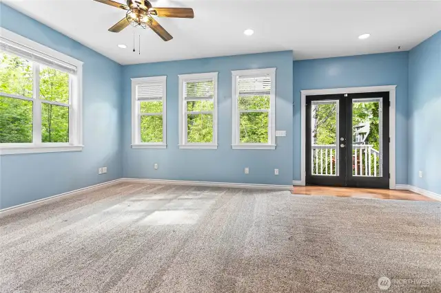 This space is massive. Enough room for a living space and sitting area. Those French doors lead to a small deck and full-fenced private patio with an exit to the driveway.