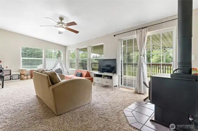 Large family room has a wood burning stove and tons of natural light!