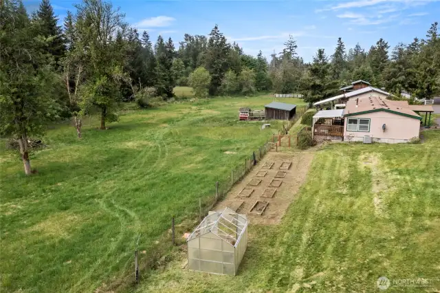 Looking to the west, greenhouse and multiple raised beds for all your planting desires!