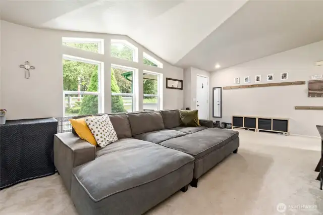 Entryway into a light and bright living room with vaulted ceiling.