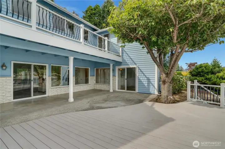 Multiple outdoor living spaces—including a covered patio, Trex deck, and upper deck—bring the bay to you.