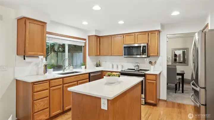 Updated island kitchen offers quartz counters and stainless steel appliances