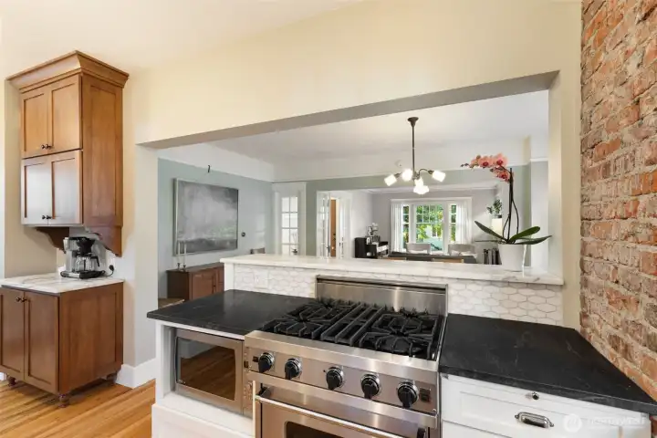 The materials used in this kitchen design blend perfectly with the era of the home- the backsplash is marble tile, and the countertops are schist stone slab.