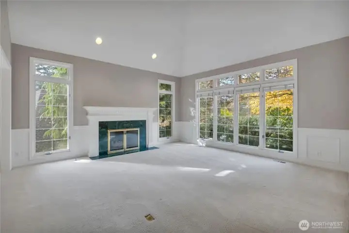 Living room with gas fireplace and large windows.
