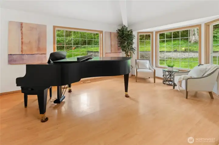 The formal living room is surrounded by windows ~ a perfect place for guests to gather.